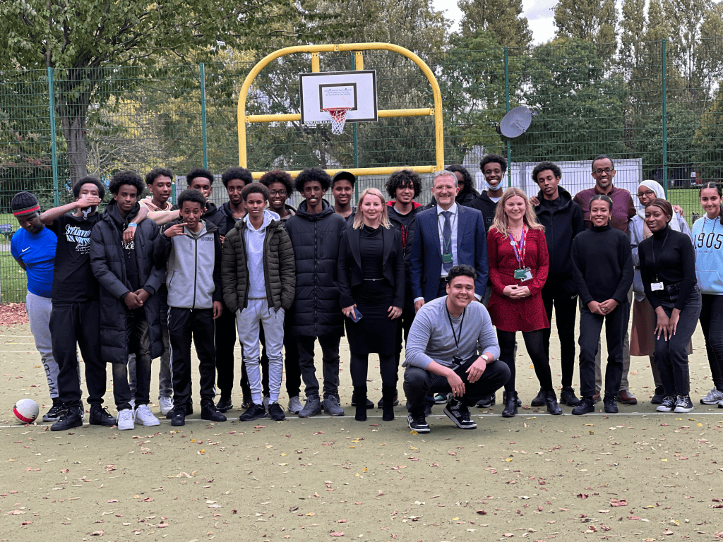 Engaged youth group at Wandsworth basketball court for community participation.