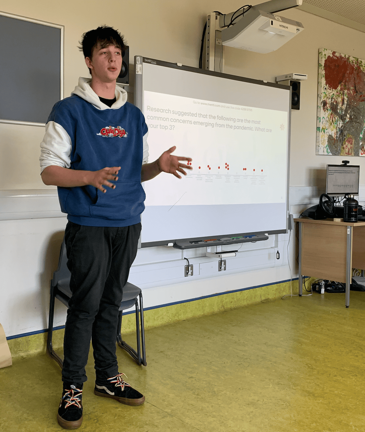 Engaged young person delivering a presentation on health research to peers using interactive whitebo.