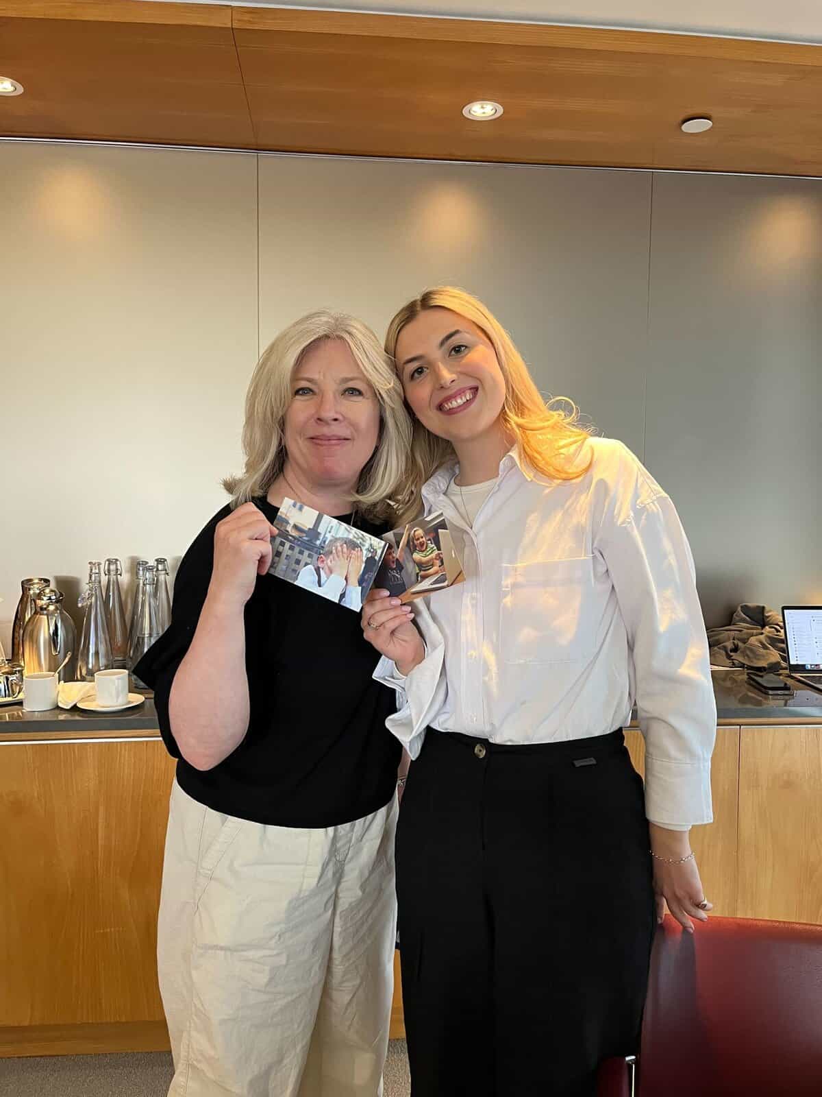 Two women smiling and holding event badges at GSMA conference on connectivity.