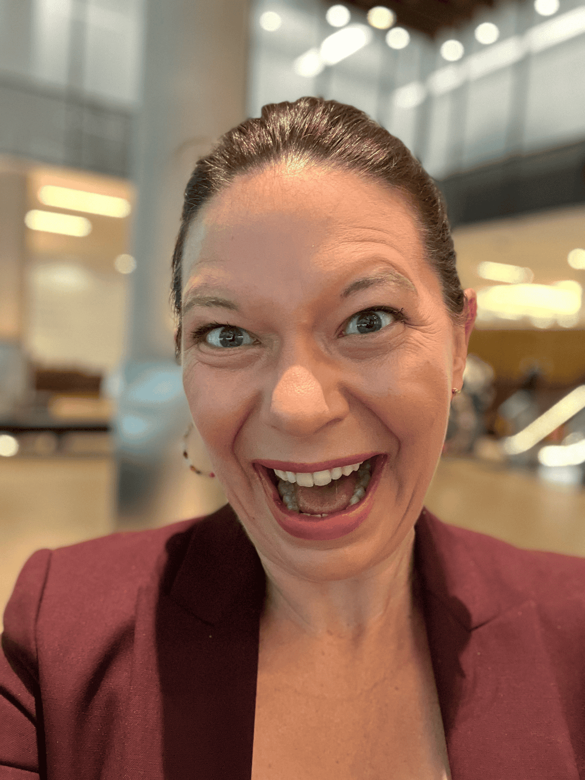 Woman smiling at GSMA event, highlighting youth connectivity in business.